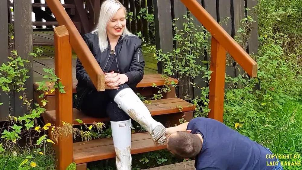 Spaziergänger leckt Gummistiefel sauber