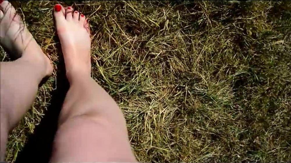 Schnelles outdoor Pissen Reife Füsse Rote Nägel im gras